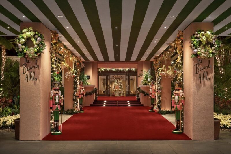Exterior shot of The Beverly Hills Hotel. The atrium is decorated with wreaths, garlands, and nutcrackers