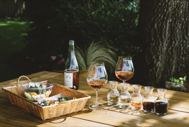 Image of wines and a basket full of cheese on a table