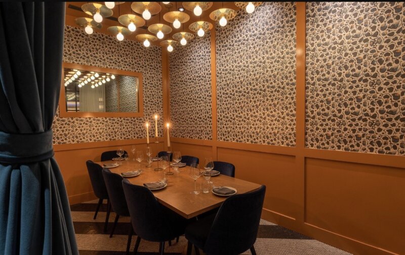 Picture of HIDE + SEEK's private dining room space. Inside the dining room sits a table with glassware and plates on top. 