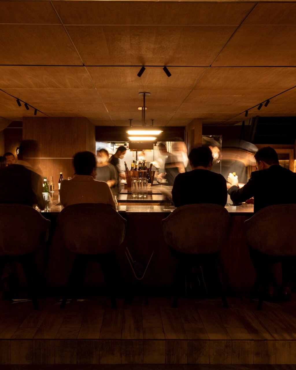 Guests dining at Atomix with chefs in action behind the counter