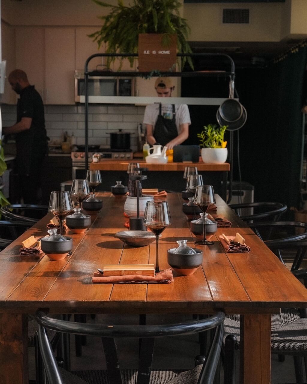 Dining table at Ilé with chefs prepping in the background