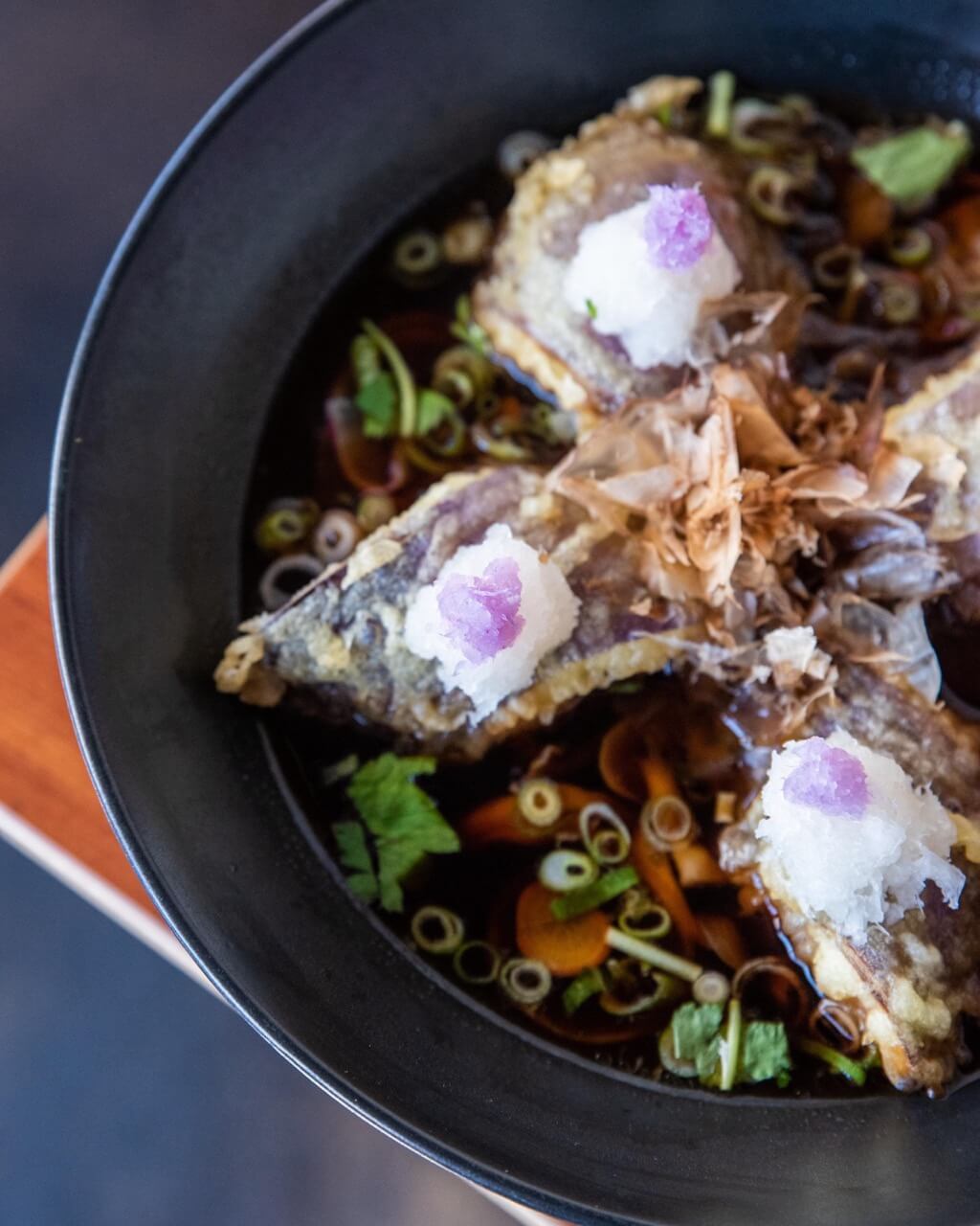 Bowl of soba noodles in dark broth with tempura