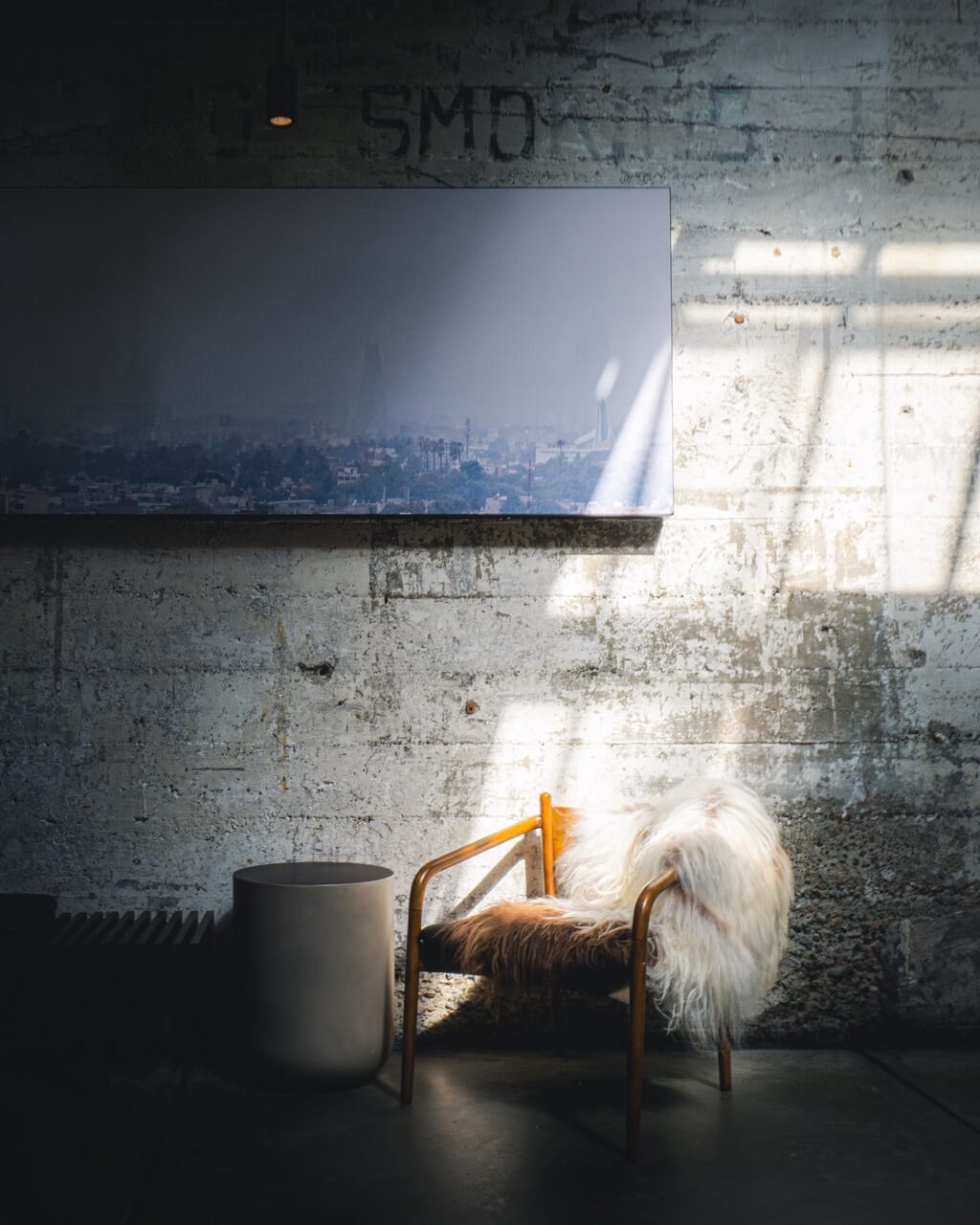 Accent chair bathed in light against a dark industrial wall
