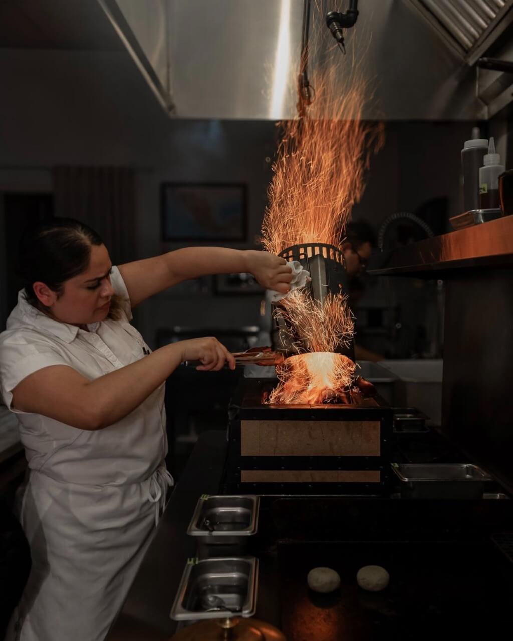 Chef cooking with fire in the kitchen at Tatemó