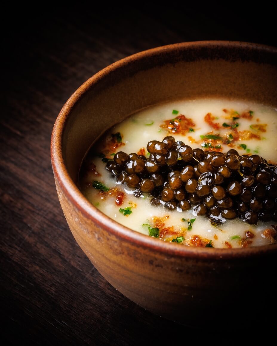 Bowl of white liquid with dollop of caviar