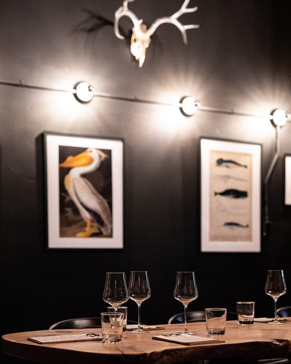 Set table at Idelwild Wines with blurred animal art and decor in background