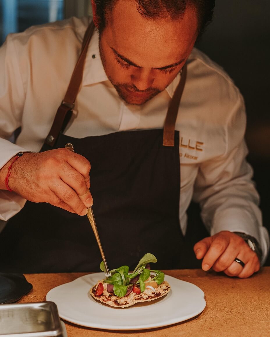 Chef Roberto Alcocer plating a dish with tweezers