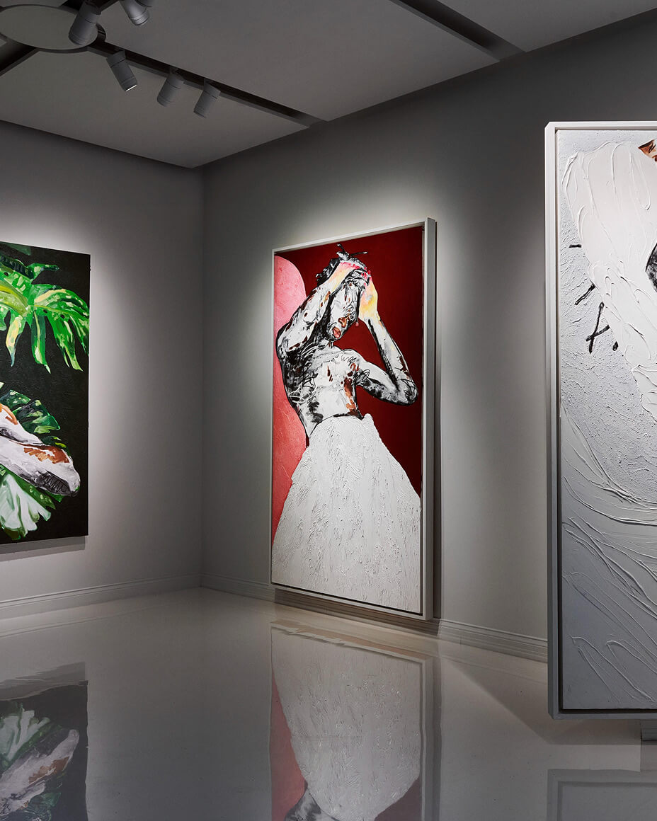 Art gallery at FREVO with large paintings, one painting revealing the door to FREVO’s restaurant space