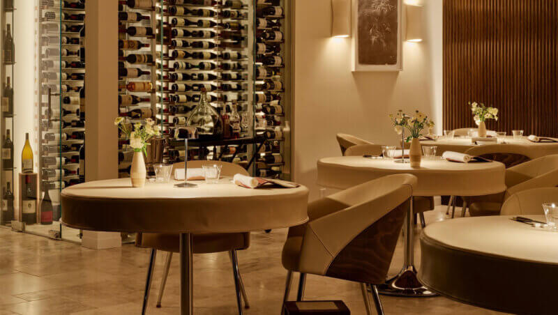 Empty dining room with wine cellar in the background at La Bastide