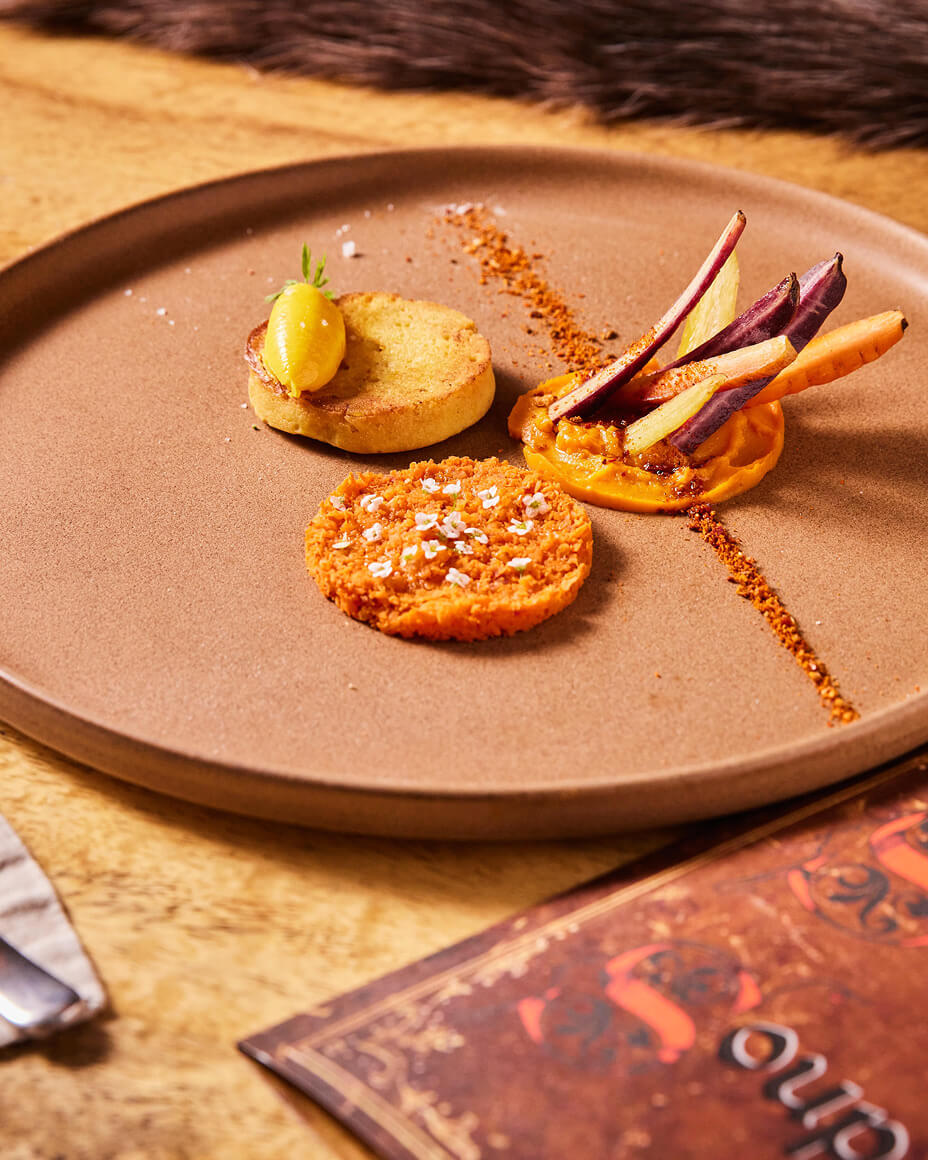 Brown stone plate with three circular plated arrangements of food