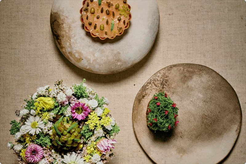 Photograph of three elegantly plated dishes from the summer menu at Sons & Daughters